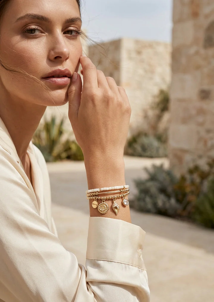 Gold triple layered stretch bracelet with fossil charm